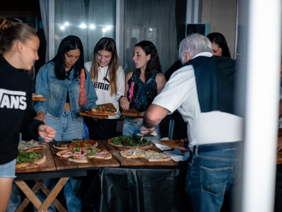 Invitados sirviéndose pizza en un evento